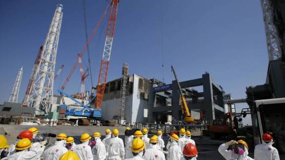 Radioactive route: Journalists in protective gear are taken to the No. 4 reactor building at the Fukushima No. 1 nuclear plant on March 6. (Photo:  AP)