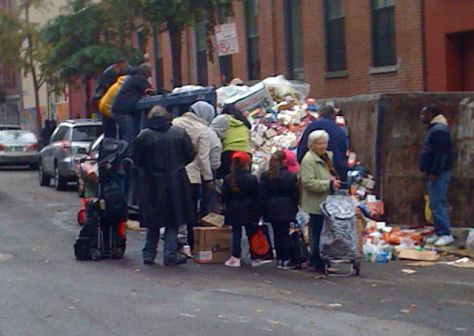 People scavenging for food in a dumpster where a Key Food supermarket has discarded spoiled food, due to power outages after Hurricane Sandy hit New York (Photo: Mr. Choppers) 